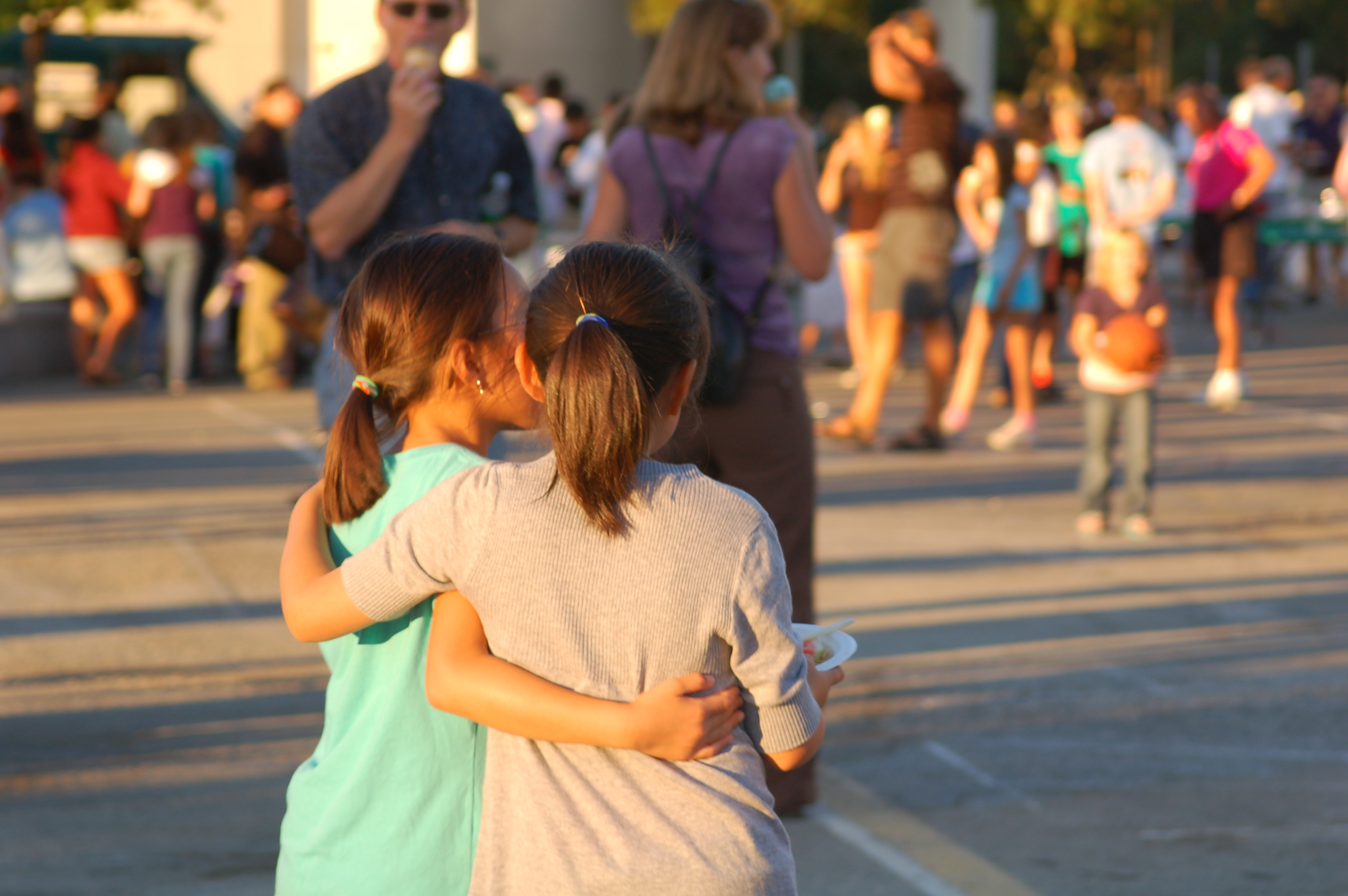 two young girls with arms wrapped around each other